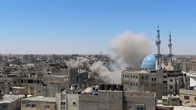 Israeli airstrike hitting the town of Rafah, smoke billowing.