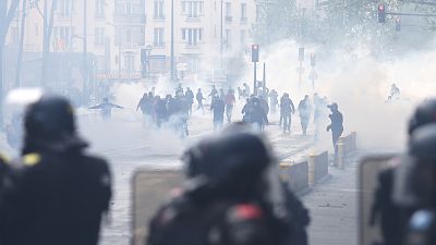 Protesters, surrounded by tear gas, face French riot mobile gendarmes in Paris.