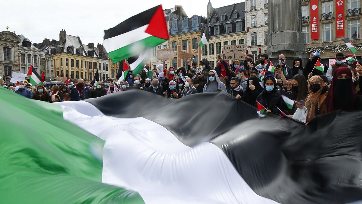 People hold Palestinian flags during a demonstration in Lille, northern France, Saturday May 15, 2021. 