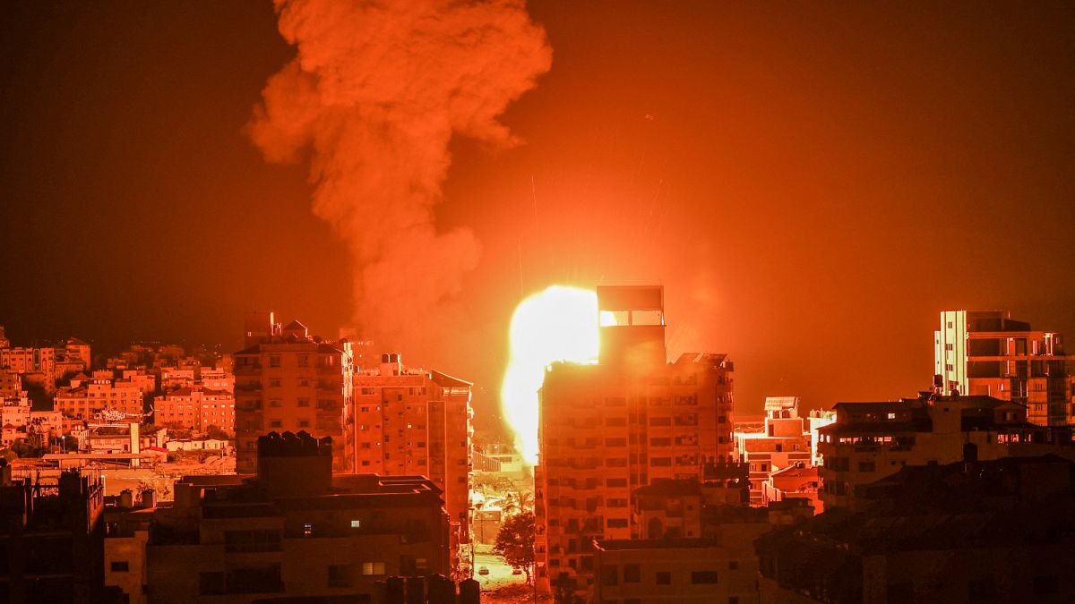 نيران ودخان يتصاعدان فوق المباني في مدينة غزة مع استهداف الطائرات الحربية الإسرائيلية للجيب الفلسطيني ، في وقت مبكر من يوم 17 مايو ، 2021.