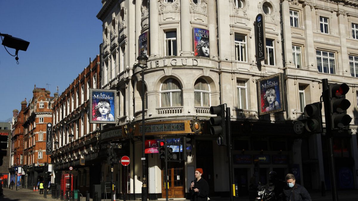 In this Friday, Feb. 26, 2021 file photo, signs for Les Miserables are displayed on the temporarily closed Gielgud Theatre during England's third coronavirus lockdown.