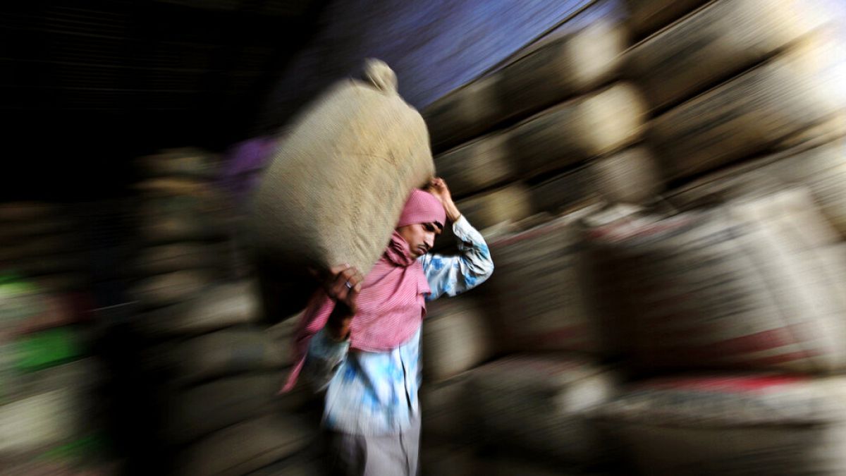 In this photo taken Tuesday, April 17, 2012, an Indian worker carries a sack of tea at a tea factory in Amritsar, India