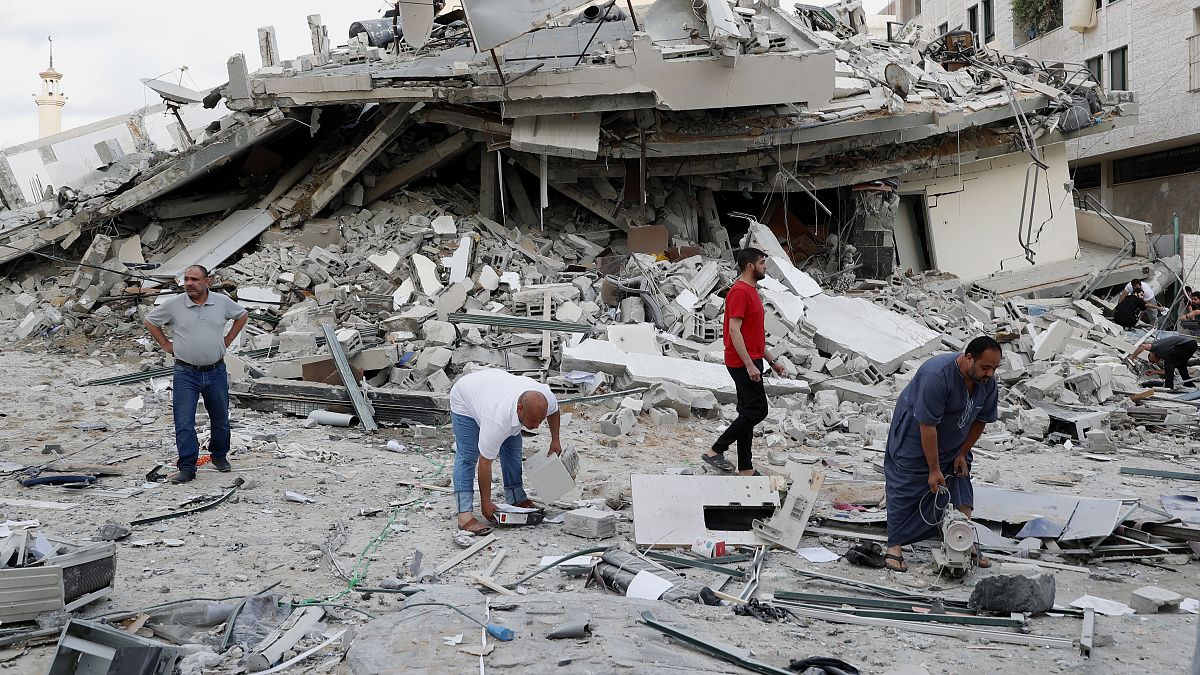 Ciudadanos palestinos buscan restos de sus pertenencias entre las ruinas en Gaza