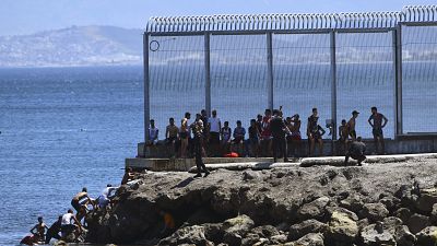 Spanish Guardia Civil officers try to stop people from Morocco entering into the Spanish territory at the border of Morocco and Spain, at the Spanish enclave of Ceuta 
