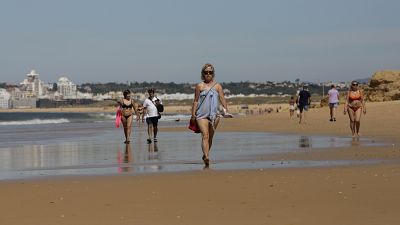 Turistas pasean por la playa en el Algarve