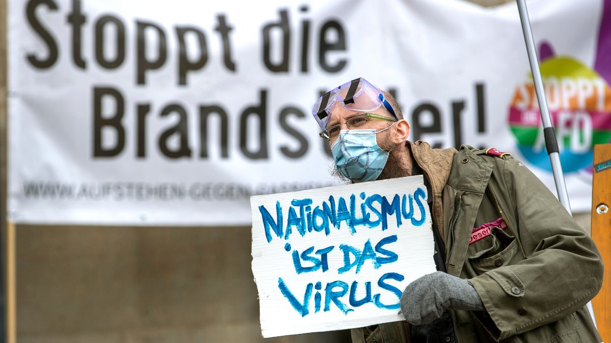 Ativista numa contramanifestação a criticar um protesto negacionista na Alemanha
