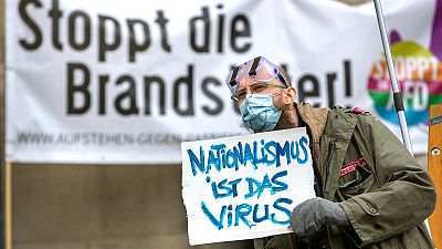 Ativista numa contramanifestação a criticar um protesto negacionista na Alemanha