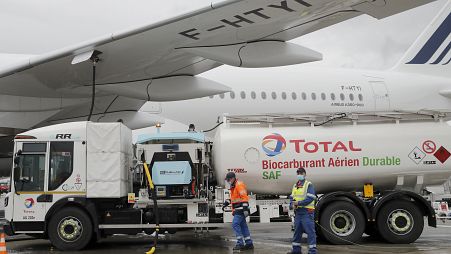 Workers refuel an Airbus A350 with sustainable aviation fuel at Roissy airport, north of Paris, Tuesday, May 18, 2021. 