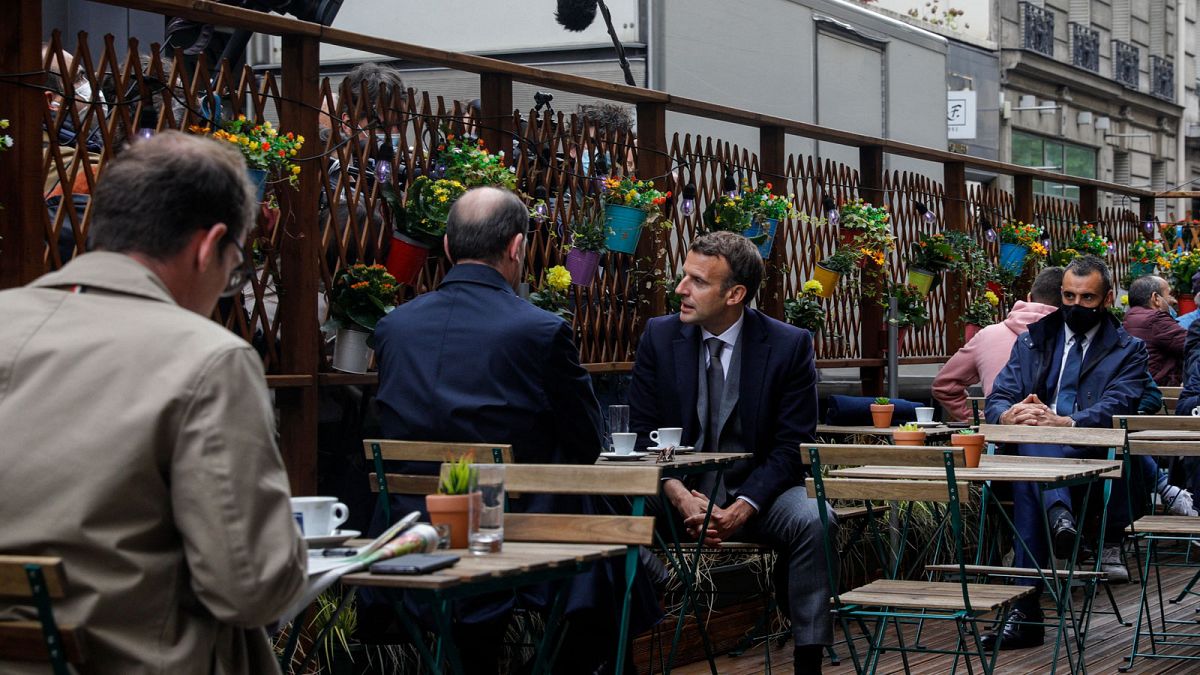 Emmanuel Macron et Jean Castex en terrasse d'un établissement parisien, prenant un café devant de nombreux objectifs, le 19 mai 2021