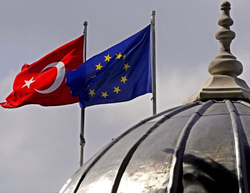 Turkish and European Union flags are seen over the dome of a mosque in Istanbul, October 2005
