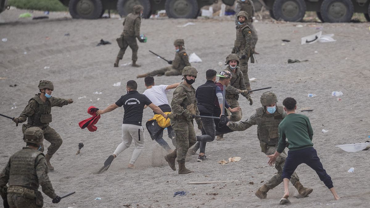 Un grupo de soldados se enfrenta a migrantes en la playa de Ceuta
