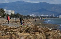 People walk along the beach after storm Gloria battered Spain's eastern coast in Torremolinos, Spain, Sunday, Jan. 26, 2020