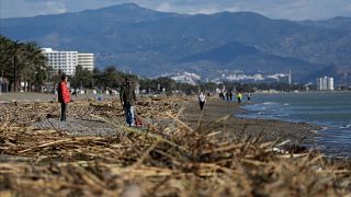 People walk along the beach after storm Gloria battered Spain's eastern coast in Torremolinos, Spain, Sunday, Jan. 26, 2020