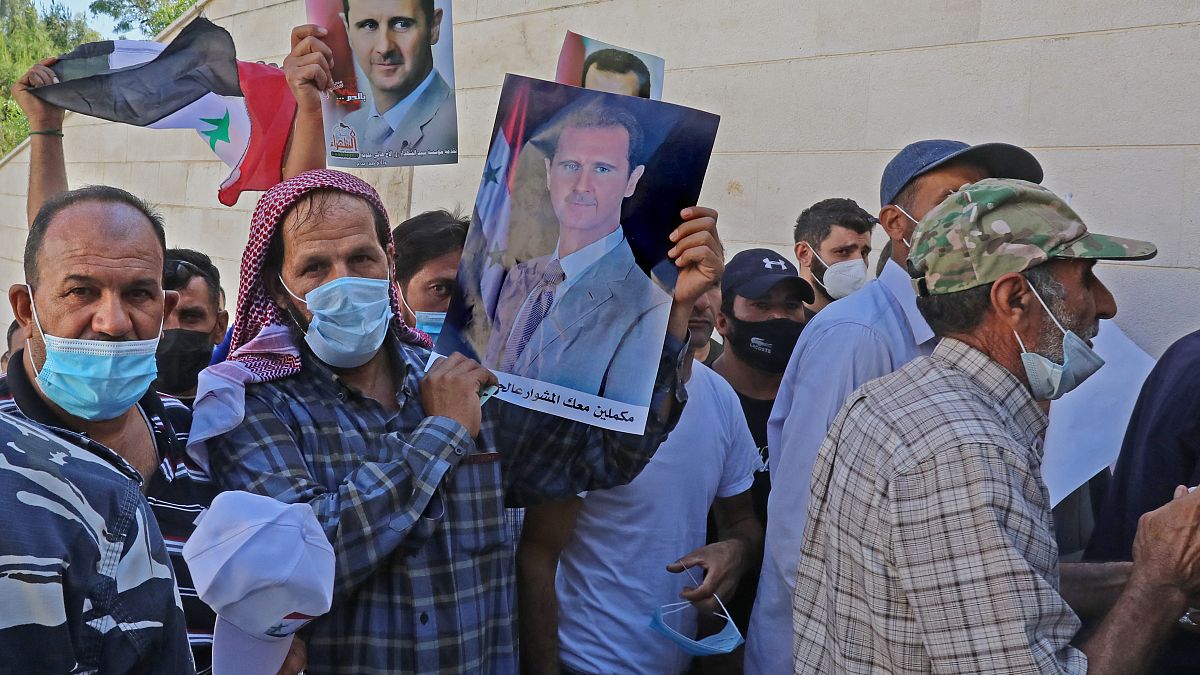 ناخبون سوريون مقيمون في لبنان يحملون صوراً للرئيس بشار الأسد،  أمام السفارة السورية بعبدا لبنان. 