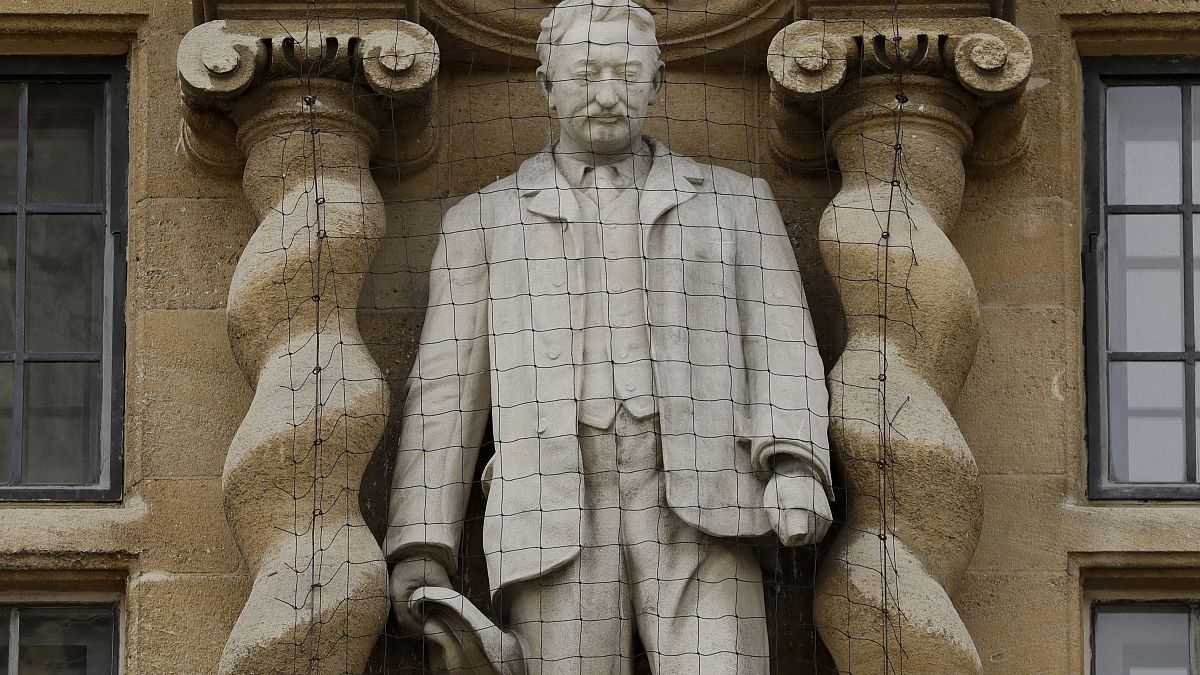 A statue of Cecil Rhodes, a controversial Victorian imperialist, stands mounted on the facade of Oriel College in Oxford, England, June 17, 2020.