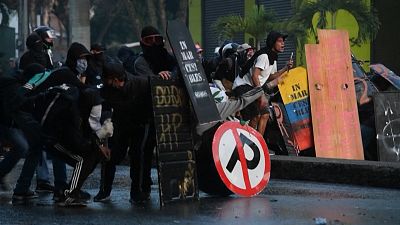 Demonstrators behind makeshift shields during clashes.