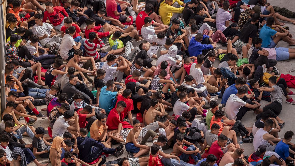Cientos de menores no acompañados aguardan sentados en el centro de acogida de El Tarajal de Ceuta