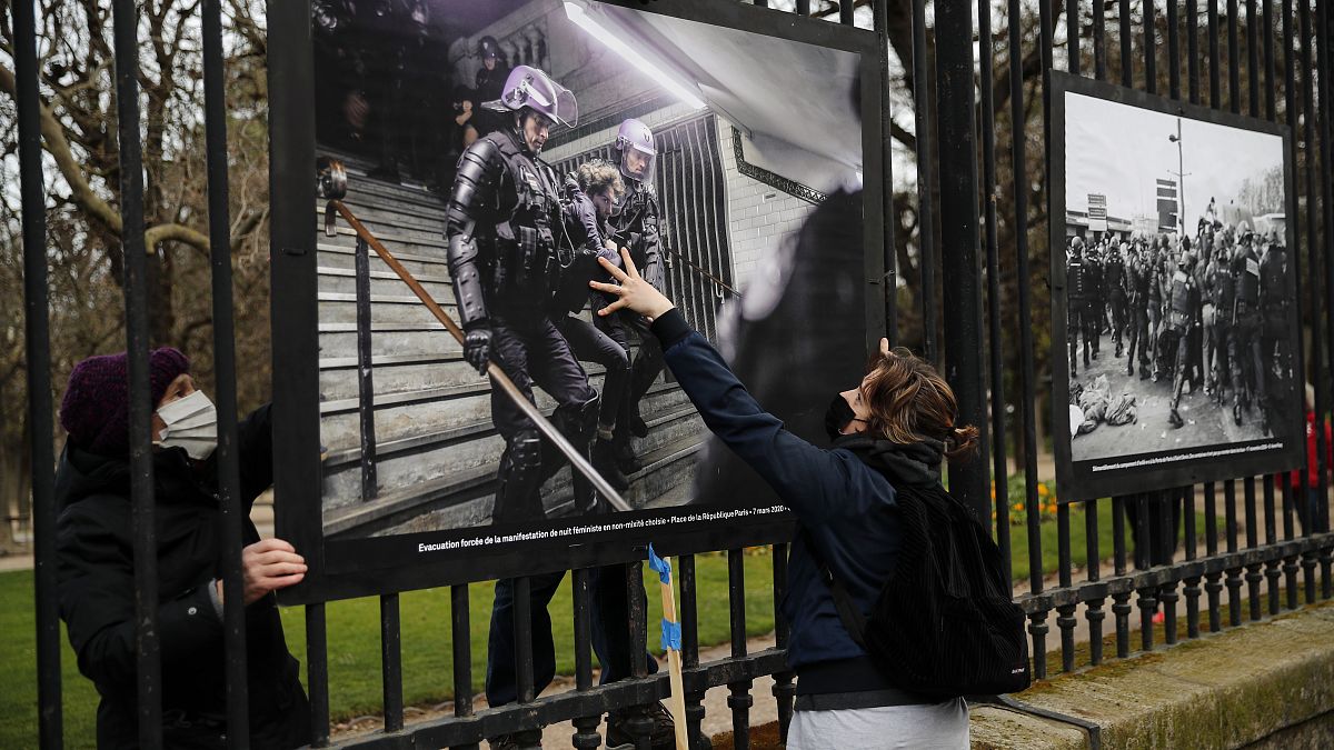 Photos of police violence are hung on the fences of the Luxembourg garden during a protest against the global security bill in Paris, Thursday, March 18, 2021. 