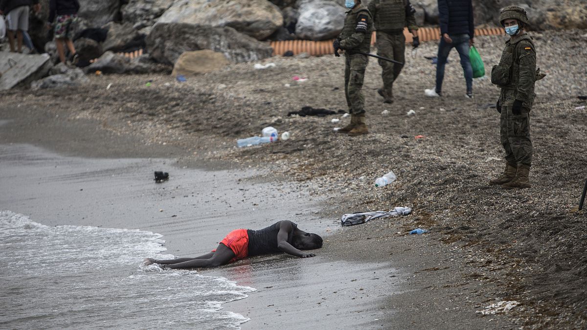 رجل ملقى على شاطى البحر فيما الجيش الإسباني يطوق المكان على اطراف مدينة سبتة، الجيب الإسباني في المغرب, 2020/05/18