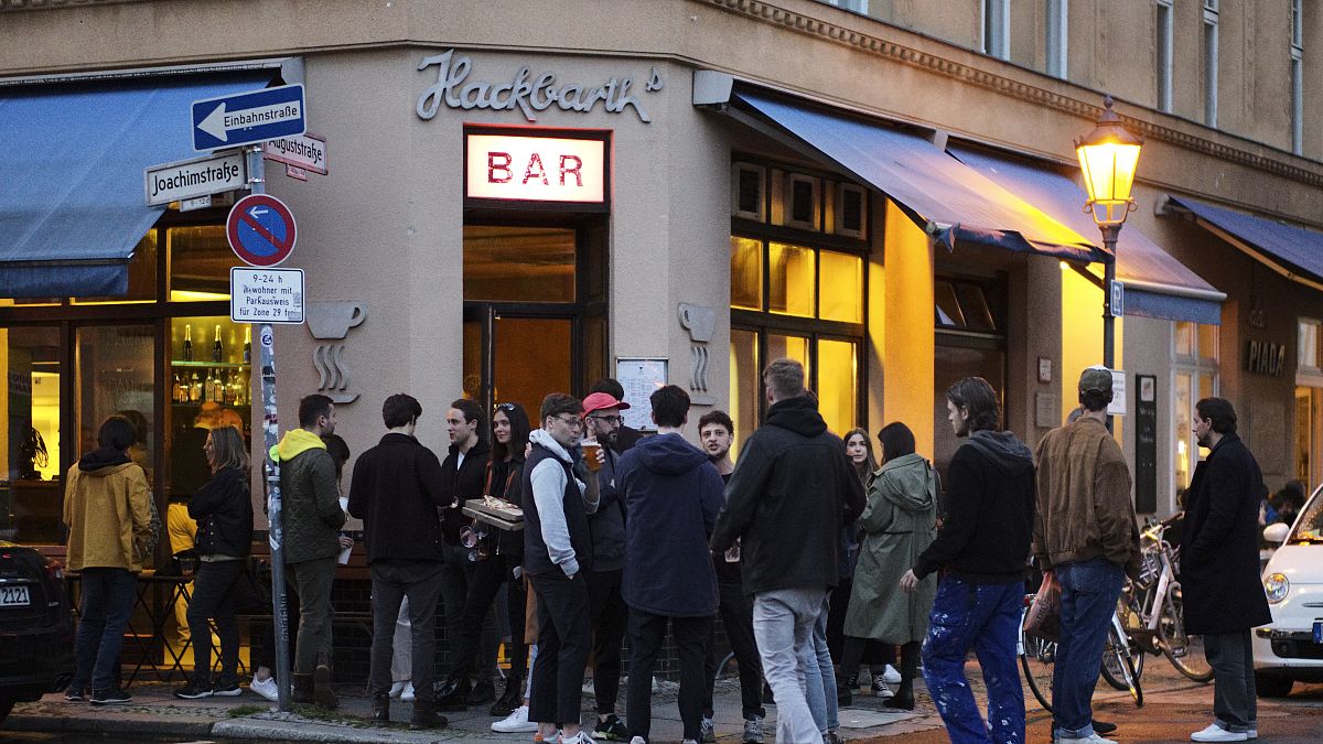 Un grupo de jovenes reunidops en la puerta de un bar en Berlín