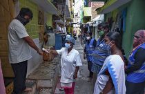 In this May 6, 2021 photo, an Indian health worker checks body temperatures during a door-to-door survey being conducted as a precaution against COVID-19 in Hyderabad, India.