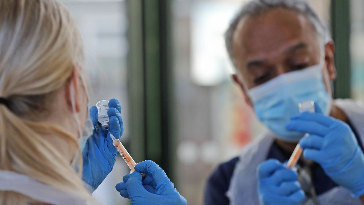 Doctor Anil Mehta and Apprentice Nursing Associate Ellie Bull prepare syringes with doses of the AstraZeneca vaccine at the Welcome Centre in Ilford, on Feb. 5, 2021 