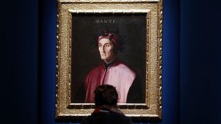 A woman looks at a portrait of poet Dante Alighieri at an exhibition, in Forlì, Italy, Saturday, May 8, 2021