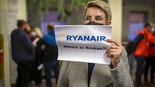 A woman holds a poster reads "where is Raman Pratasevich?!" at the International Airport outside Vilnius, Lithuania, Sunday, May 23, 2021.