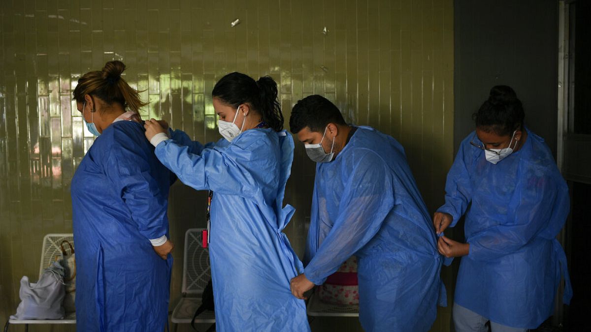 Government doctors put on protective gowns as they prepare to give free, rapid COVID-19 tests to residents who volunteer in the El Paraiso neighborhood of Caracas, Venezuela