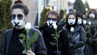 الملابس السوداء والأفواه المكممة والورود البيضاء للاحتجاج في مينسك في 2 مارس 2021.
