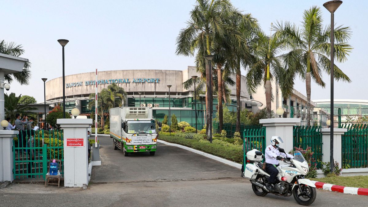 Yangon International Airport can be seen on Friday, Jan. 22, 2021, in Yangon, Myanmar, as traffic police lead trucks carrying COVID-19 vaccines. 