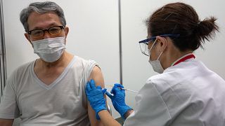 Egy férfi megkapja a Moderna amerikai cég koronavírus elleni oltóanyagát az újonnan létesített tokiói oltóközpontban 2021. május 24-én. 