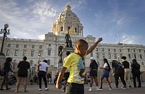 Un niño sostiene su puño en alto en una concentración organizada por el primer aniversario del asesinato de George Floyd el lunes 24 de mayo de 2021