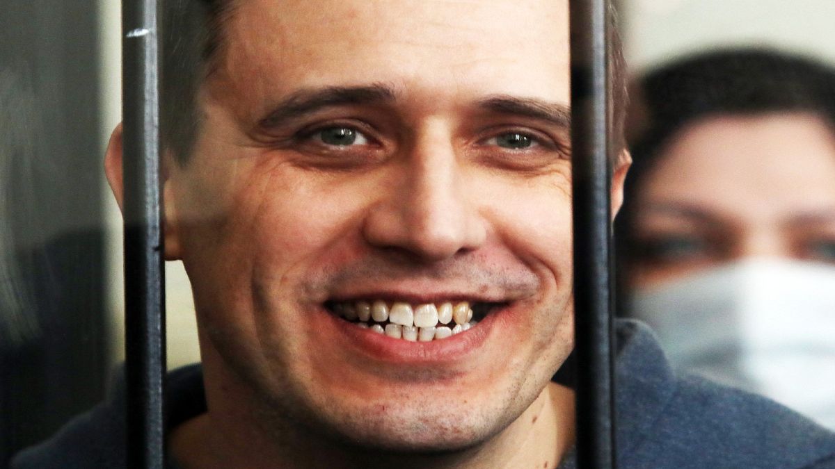 Belarus opposition figure Pavel Severinets smiles from the defendant's cage at a courthouse, on May 25, 2021