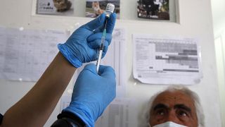 Une infirmière s'apprête à réaliser une injection du vaccin anticovid Pfizer à un homme sur l'île d'Iraklio, en Grèce, le 13 mai 2021