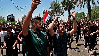 Anti-government protesters chant slogans as they hold posters of slain activists outside the Green Zone area in Baghdad, Iraq, Tuesday, May 25, 2021. 