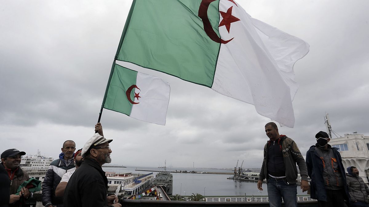 جزائريون يحملون علم بلادهم خلال إحدى الفعاليات في العاصمة الجزائر في 16 أبريل 2021