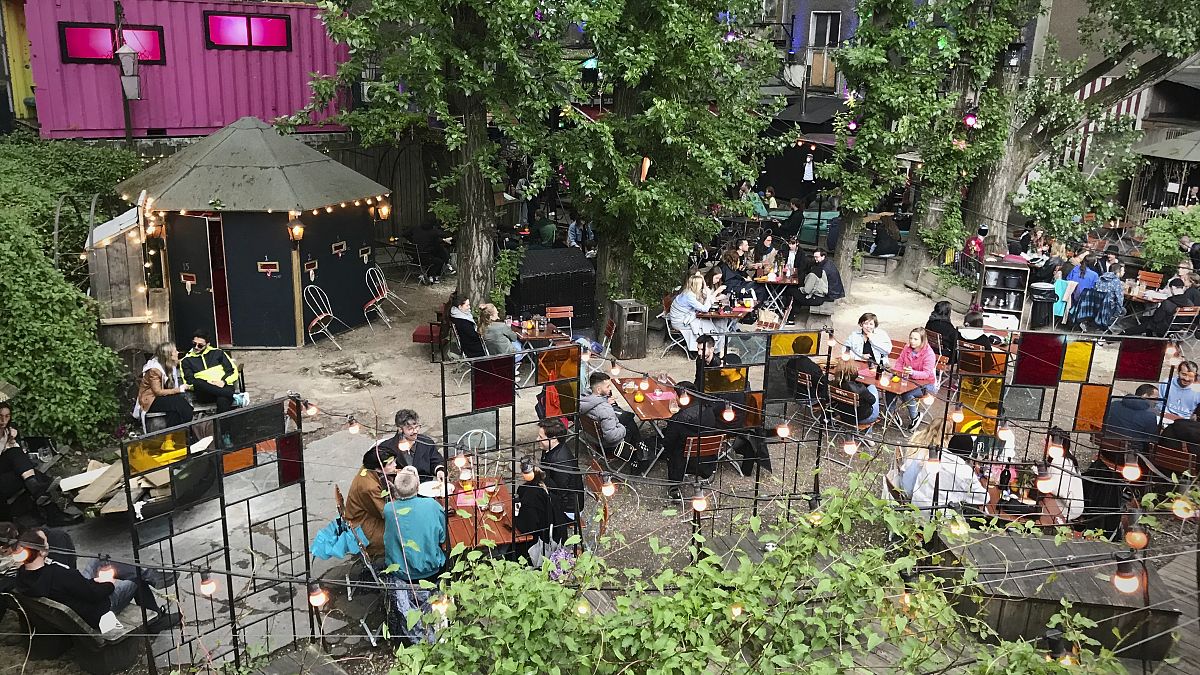 This Saturday May 22, 2021 taken photo shows people sitting at the 'Wilde Renate' beer garden in Berlin, Germany. 