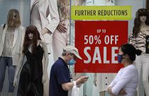 Shoppers pass a sale sign in a shop window on Oxford Street in London, Aug. 13, 2020.