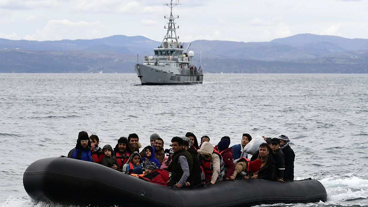 People arrive in a dinghy accompanied by Frontex vessels, on the Greek island of Lesbos