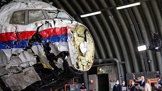 Presiding judge Hendrik Steenhuis, right, points as he and other trial judges and lawyers view the reconstructed wreckage of Malaysia Airlines Flight MH17