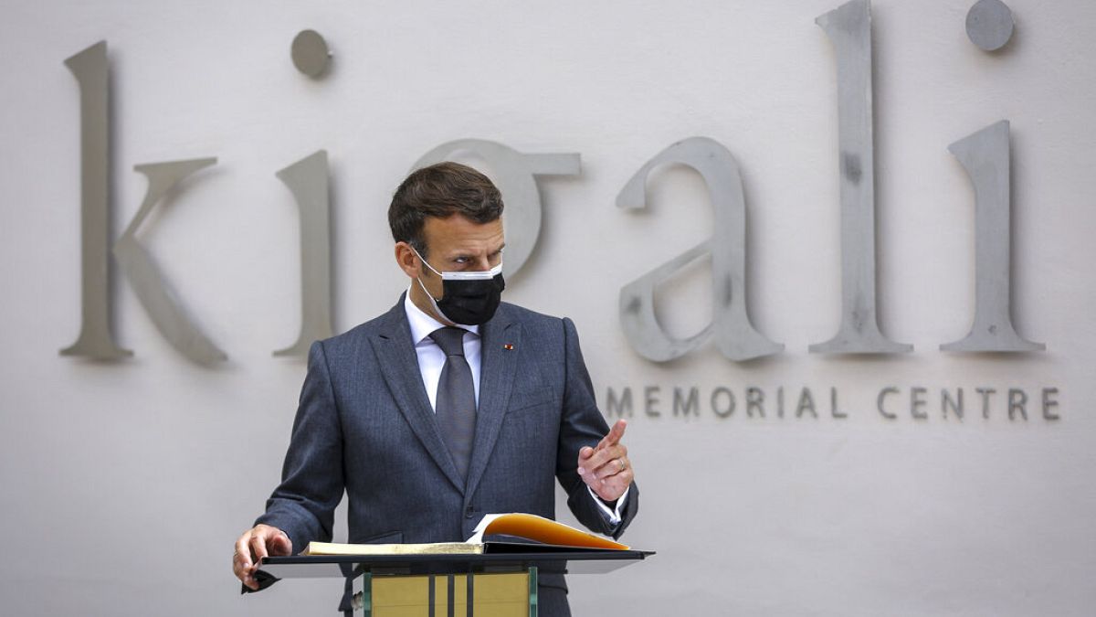 French President Emmanuel Macron speaks next to the visitor's book at the genocide memorial site in the capital Kigali, Rwanda 