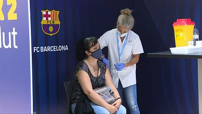 امرأة تتلقى حقنة من لقاح فايزر المضاد لكورونا في ملعب كامب نو في برشلونة في 27 مايو 2021.