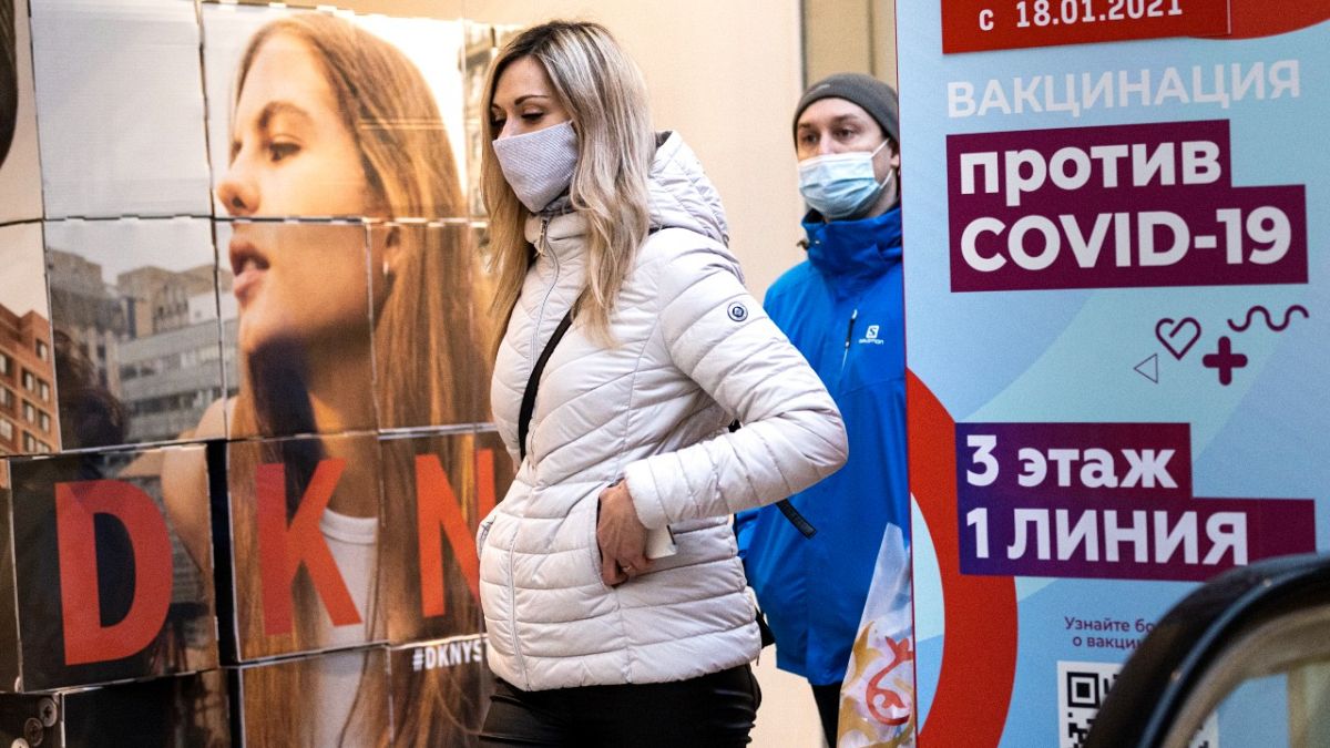 Frau vor Impfplakat in Moskau