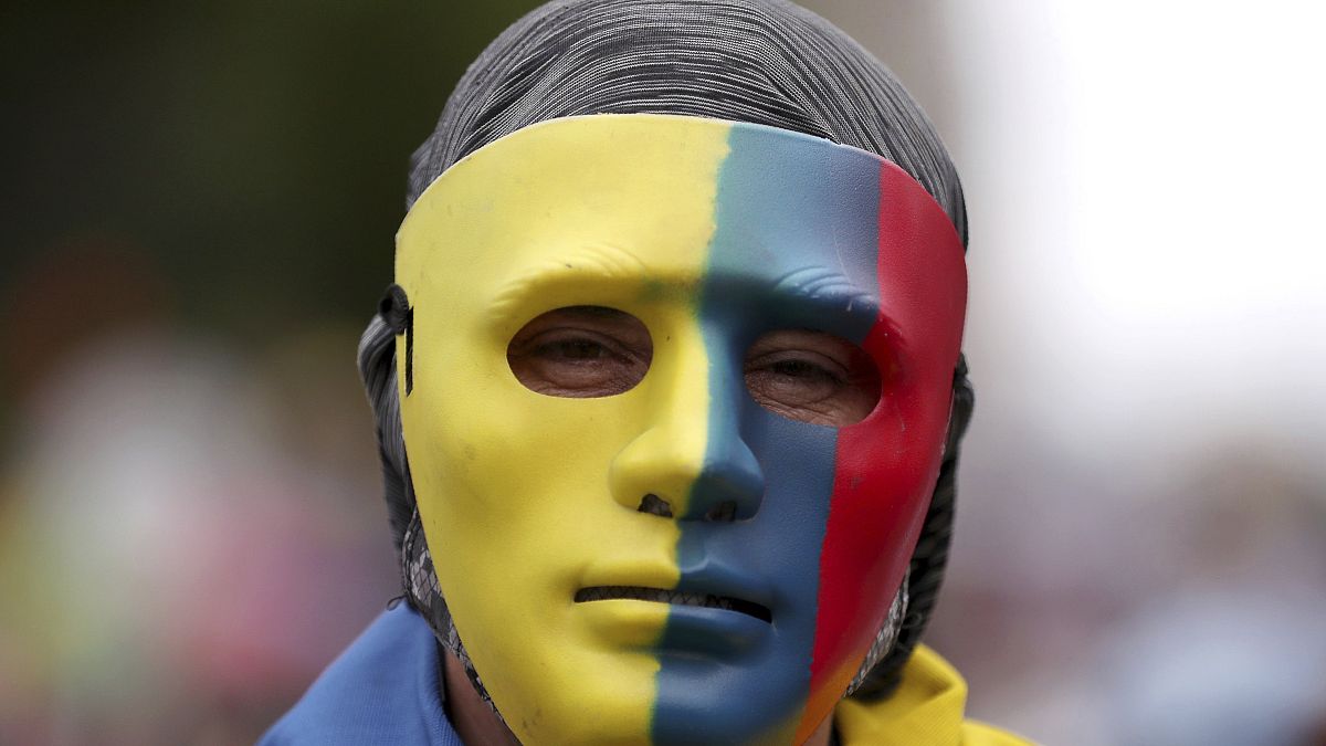 Un manifestante cubre su rostro con una máscara con los colores de la bandera colombiana en Bogotá, el 26 de mayo de 2021.