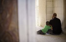 Un bambino palestinese abbraccia il padre
