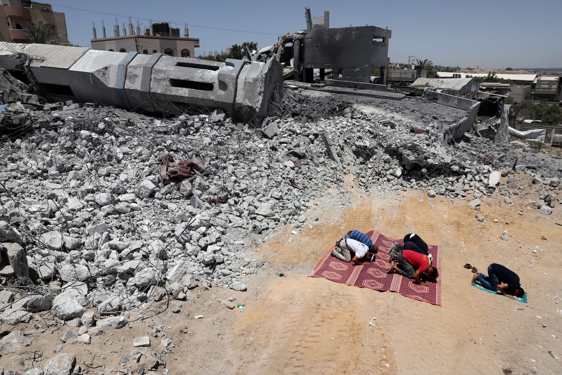 Palestinian Muslim worshippers pray near the rubble of a destroyed mosque in Beit Lahia, in the northern Gaza Strip. May 27, 2021