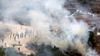 متظاهرون فلسطينيون يرشقون الحجارة وسط دخان الغاز المسيل للدموع الذي أطلقته قوات الأمن الإسرائيلية في قرية بيتا في جنوب نابلس في الضفة الغربية المحتلة. 28 مايو 2021.