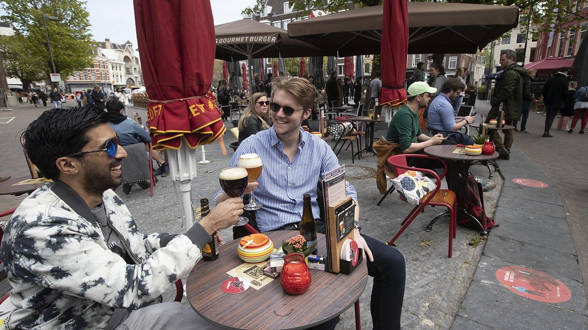 In this Wednesday, April 28, 2021 file photo, people toast after terraces reopened at midday as the Netherlands began cautiously relaxing restrictions.