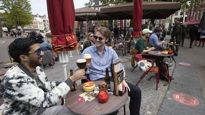 In this Wednesday, April 28, 2021 file photo, people toast after terraces reopened at midday as the Netherlands began cautiously relaxing restrictions.